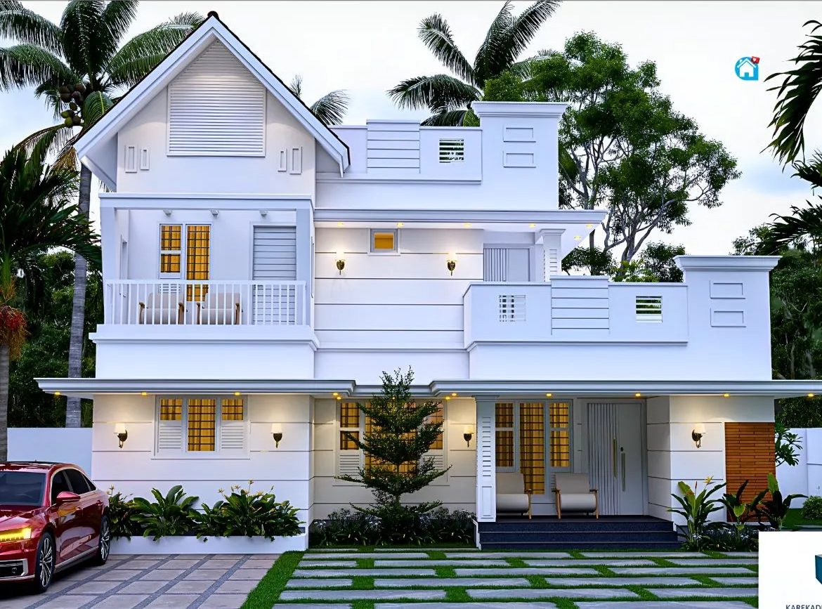 A two-storey white Kerala-style home among coconut palms